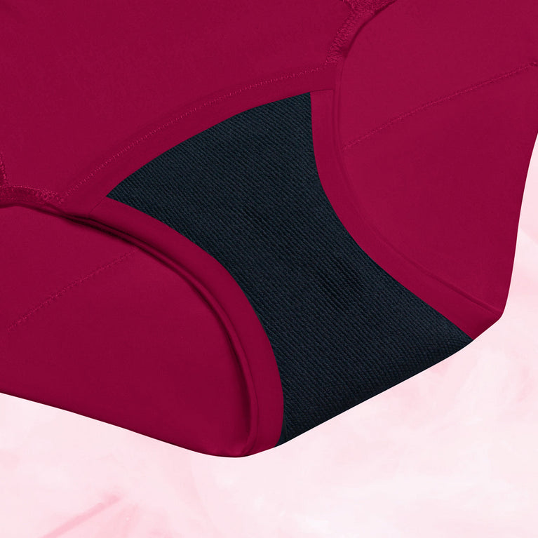 A close-up of AltText.ai - High Waist Floral Moderate red sustainable period underwear by intimawear by Bodyform™, featuring black TriTech Performance fabric in the gusset and seam detailing on the sides for comfort and durability, set against a light pink background.